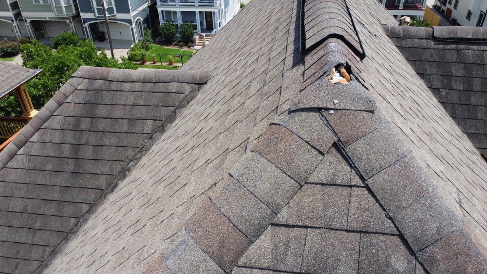 Torn ridge cap shingle with underlayment exposed