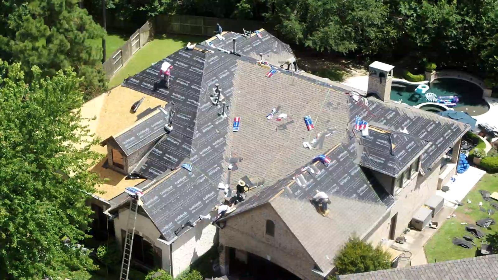 Aerial view of a roof mid-installation with underlayment