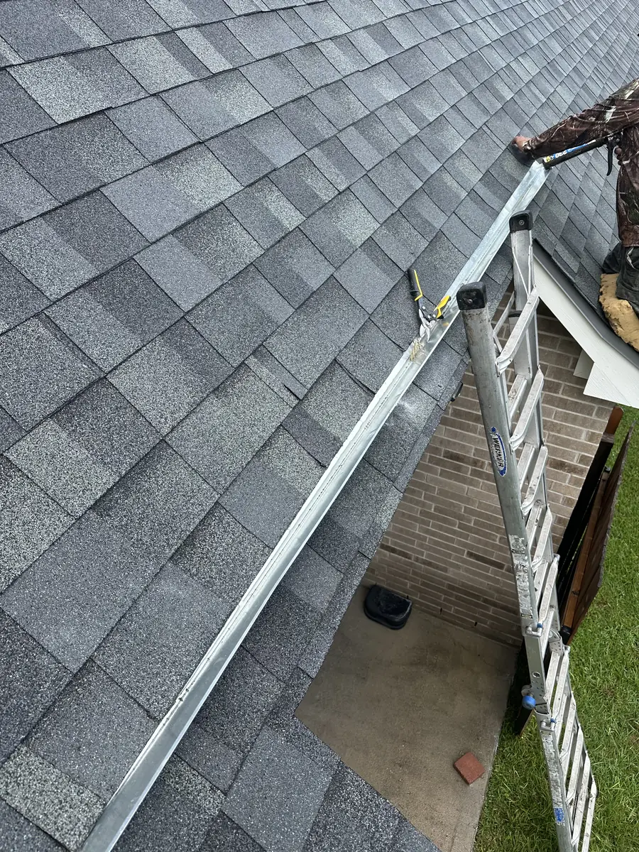 New ridge flashing being installed during a roof repair